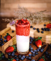 Healthy vitamin. Summer berries yoghurt smoothie in glass on rustic wooden table