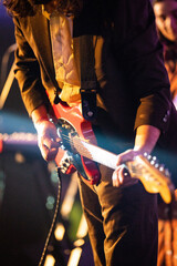 Band playing music and a gig in a venue, close up of a rock band playing guitars and instruments.