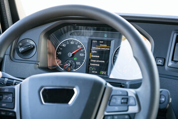 View from inside the cab of the truck. The truck is driving down the road. Car transport.