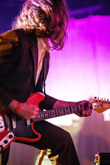 Band playing music and a gig in a venue, close up of a rock band playing guitars and instruments.