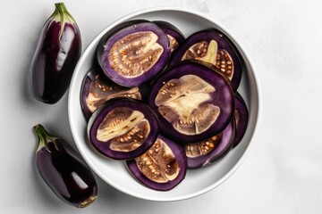 Fresh eggplant in a white bowl. View from top. Ingredients for juice, salad, dishes, cuisine.  