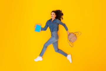 Fototapeta na wymiar Cheerful Woman Running Holding Backpack And Copybooks Over Yellow Background