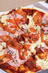 Pizza in a box on a wooden table