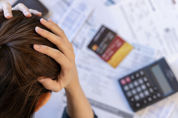 Financial owe asian woman, female sitting on table at home, stressed and confused by calculate expense from bills, have no money to pay, mortgage or loan. Debt, bankruptcy or bankrupt concept.