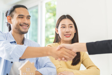 Successful asian young couple new landlord, tenant or renter handshake with home, apartment agent or realtor woman after bank approved mortgage, loan signed purchase contract. Property of financial.