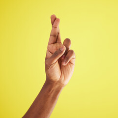 If its meant for me, itll be. Studio shot of an unrecognisable man crossing his fingers against a yellow background.