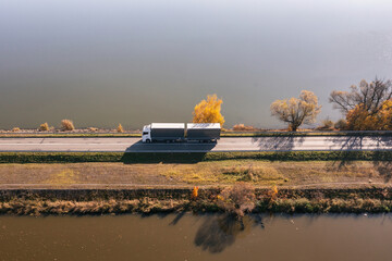 Truck goes on the road in autumn. car transport . Truck with semi-trailer in gray color.  Transport...