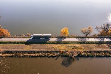 Truck goes on the road in autumn. car transport . Truck with semi-trailer in gray color.  Transport...