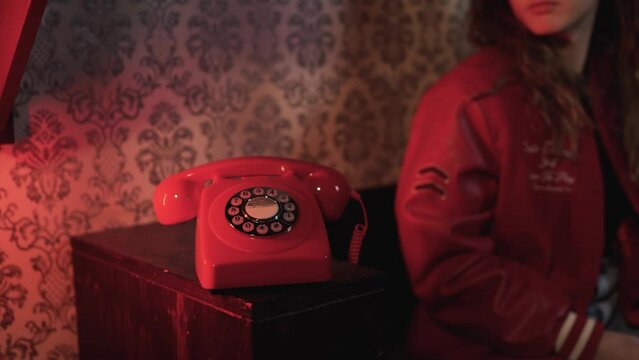 Woman answering red retro telephone