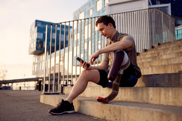 Man with a prosthetic running blade checking his phone