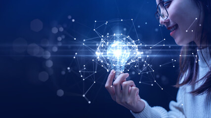 Businesswoman holding a light bulb illuminates the connection of polygons on the internet network....
