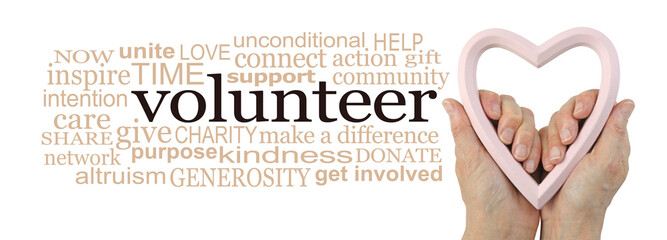Volunteer from your Heart Word Cloud Concept - female hands  holding a pink heart frame beside a...