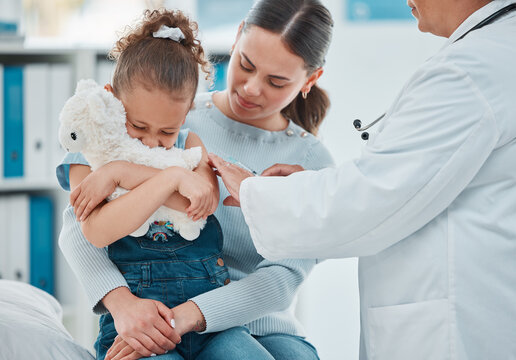 Im scared to get sore. a little girl looking scared while getting an injection from a doctor in a clinic.