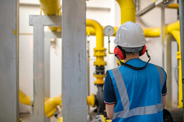 Maintenance technician at a heating plant,Petrochemical workers supervise the operation of gas and oil pipelines in the factory,Engineers put hearing protector At room with many pipes