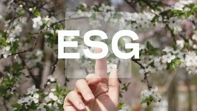 Human hand presses the ESG icon on the touchscreen.ESG concept. Investment. Environmental technology. Green nature background