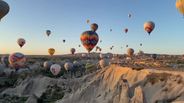 balloons floating in Cappadocia at sunrise on a clear day with sunshine and blue sky