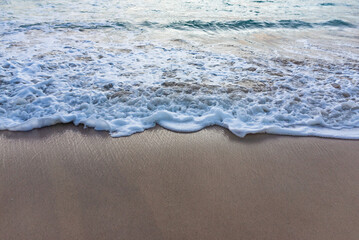 Sea waves breaking on the sandy shore