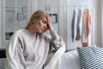 worried blonde woman with headache and fever