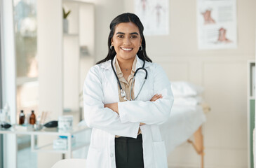 Lets make you feel better. an attractive young doctor standing alone in her clinic with her arms...