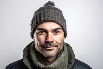 Portrait of a handsome man wearing a hat and scarf on grey background