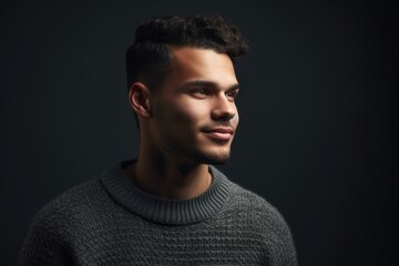 Obraz premium Portrait of a young handsome man in sweater on dark background.