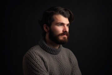 Fototapeta premium Portrait of a bearded man in a sweater on a black background