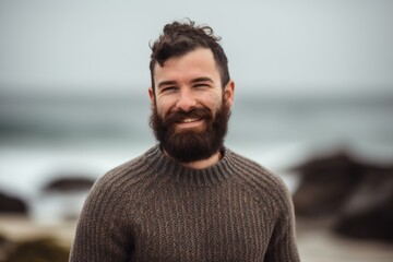 Fototapeta premium Pet portrait photography of a grinning man in his 30s wearing a cozy sweater against a beach background. Generative AI