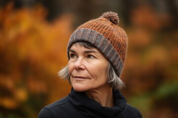 Portrait of a middle-aged woman in a knitted hat in an autumn park