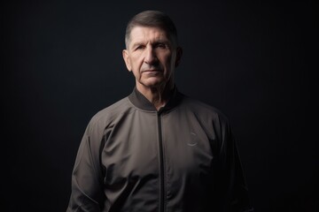 Fototapeta na wymiar Portrait of a senior man in sportswear on black background