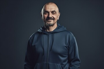 Fototapeta premium Portrait of a smiling mature man in sportswear on a dark background.