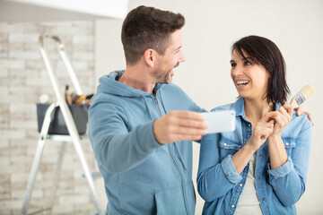 Fototapeta premium couple at home painting walls taking selfie with smartphone