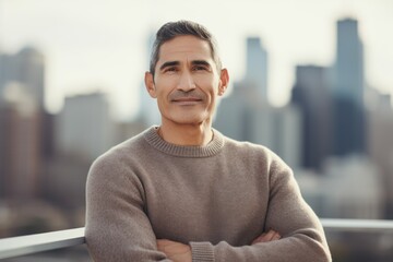 Portrait of handsome middle-aged man standing with arms crossed outdoors.