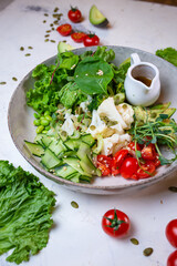 vegetarian salad with broccoli, tomato, cucumber and herbs with sauce on a plate