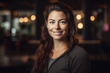 Portrait of smiling woman looking at camera in coffee shop at night