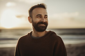 Obraz na płótnie Canvas Medium shot portrait photography of a grinning man in his 30s wearing a cozy sweater against a beach sunset background. Generative AI