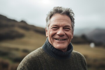 Portrait of a smiling senior man on the top of a mountain
