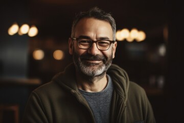 Fototapeta premium Portrait of a smiling mature man in eyeglasses standing in cafe