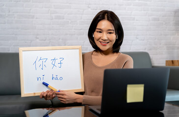 Young Asian female teacher teaching a chinese language via online distance teaching method on...