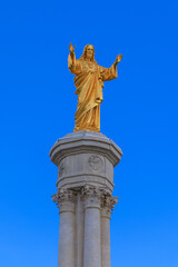Golden Christ statue on blue sky- Fatima in Portugal