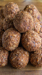 Scotch eggs on a wooden chopping board display regimentally.