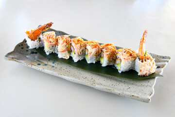 Variety of sushi rolls are presented on a plate, showcasing the colorful and fresh ingredients.