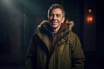 Portrait of a smiling mature man in a raincoat at night.