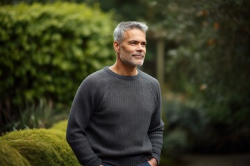 Naklejka na ściany i meble Portrait of a handsome middle-aged man with grey hair wearing a sweater