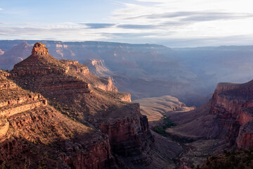 Panoramic aerial view from Bright Angel hiking trail at South Rim of Grand Canyon National Park, Arizona, USA. Vista after sunrise in summer. Colorado River weaving through valleys and rugged terrain