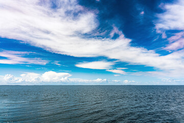 Beautiful white clouds on a blue sky over a calm sea