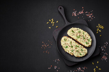 Grilled toast with avocado paste, eggs, cream cheese, salt, spices and herbs