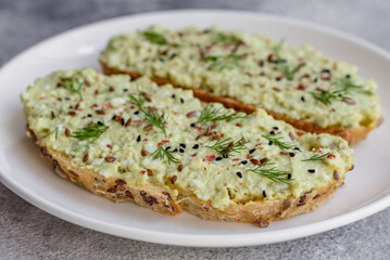 Grilled toast with avocado paste, eggs, cream cheese, salt, spices and herbs