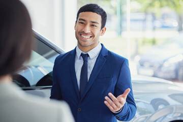 These are your options. a handsome young male car salesman talking to a female customer on the...