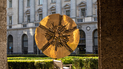 the solar disk inspired by the Aztec calendar by Arnaldo Pomodoro in the Meda square flowerbed. Milan, Lombardy, Italy