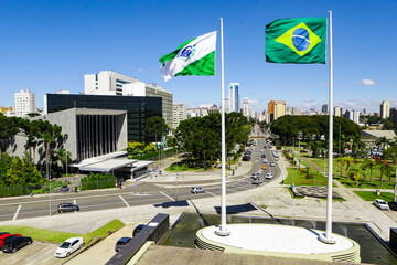 Flags of Paraná (left side), state located in the southern region of Brazil - flag on the right side, and in the background on the left side the Legislative Assembly of Paraná (Alep). - obrazy, fototapety, plakaty